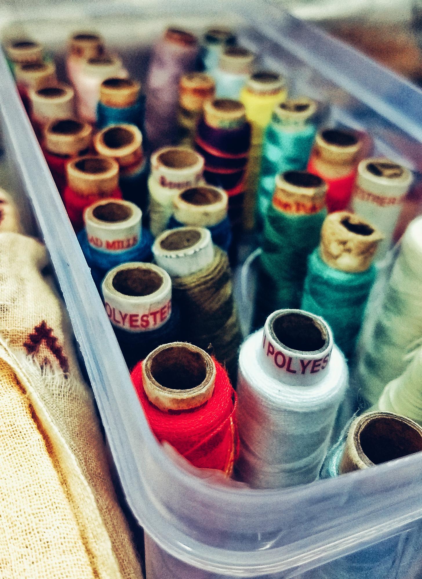 Workshop table with embroidery machines and threads neatly arranged